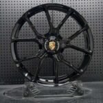 XL MONO SERIES-036 gloss black 5-split Y-spoke center-lock monoblock forged wheel front face with Porsche crest emblem
